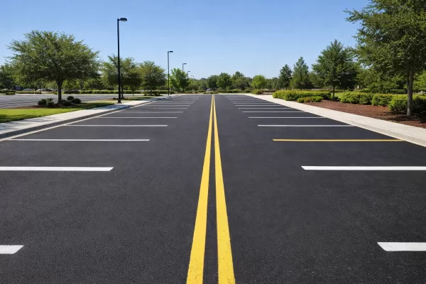 A clean, well-maintained commercial parking lot with clear striping, no debris, and smooth dark pavement, illustrating organized and proactive maintenance.