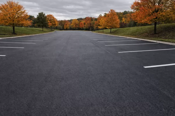 Commercial asphalt surface with protective sealed finish in autumn, free of debris and damage, anonymous setting