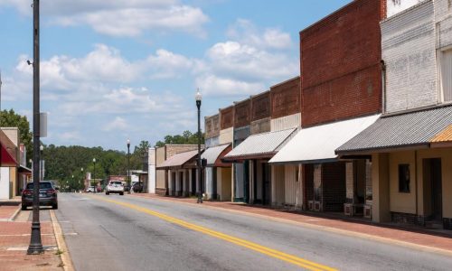 Small-town Cairo, Georgia street with low-rise historic storefronts, awnings, and a paved road.