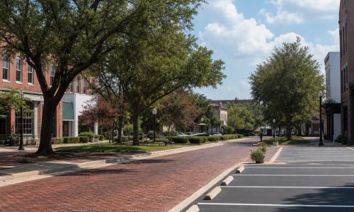 Freshly striped asphalt beside a brick historic streetscape and shaded plaza greenery in Fitzgerald, Georgia.