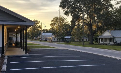 Ordinary paved streetscape in Jasper, Florida, with shaded lowland surroundings and no readable signage.
